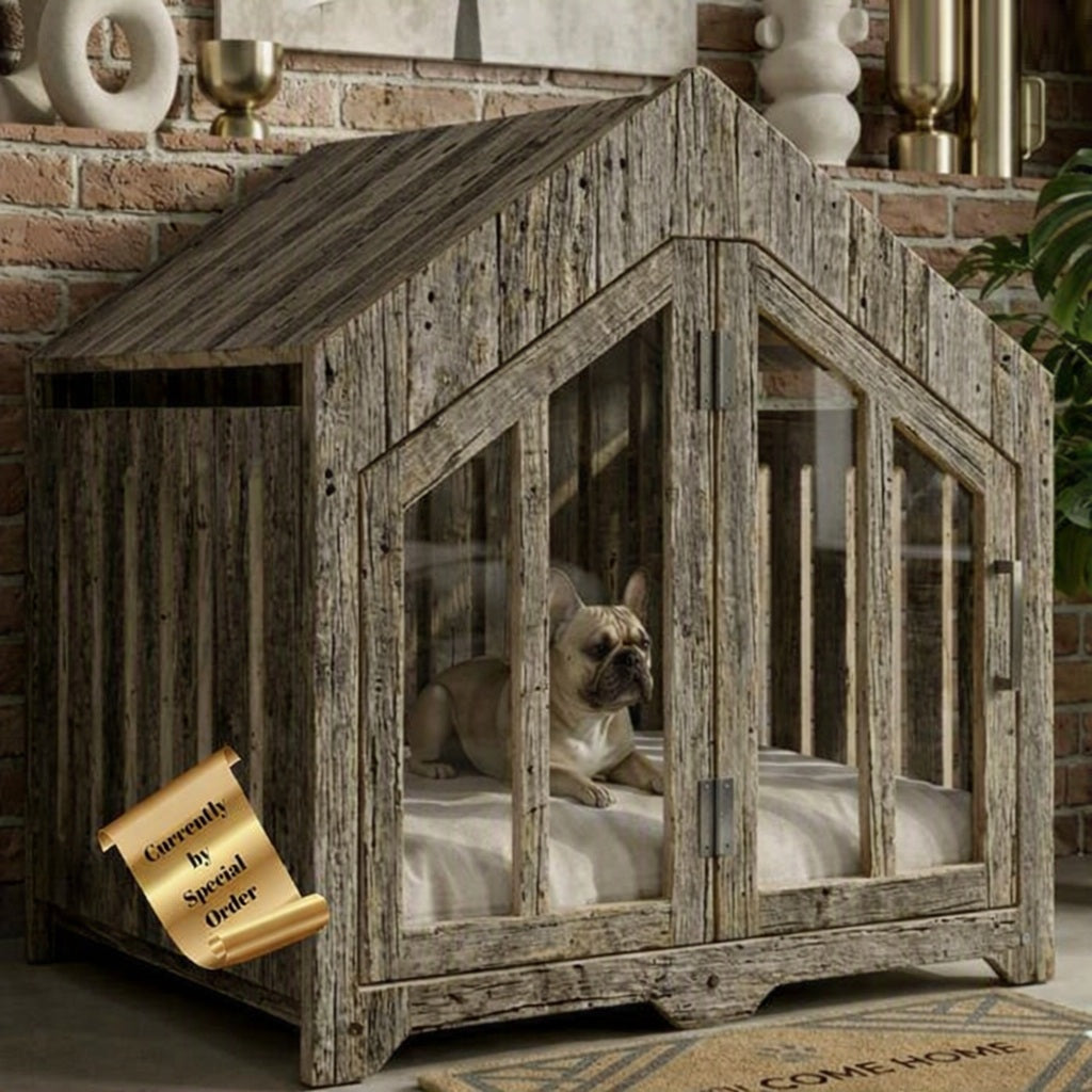 A rustic house-shaped dog crate with a weathered gray wood finish and glass doors, shown with a French bulldog inside. A gold scroll badge on the lower left reads 'Currently by Special Order'.