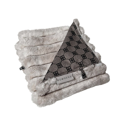 A folded plush faux fur blanket in light gray with a triangular section showing a dark gray and black monogram pattern, featuring a 'BOWSERS' brand tag.
