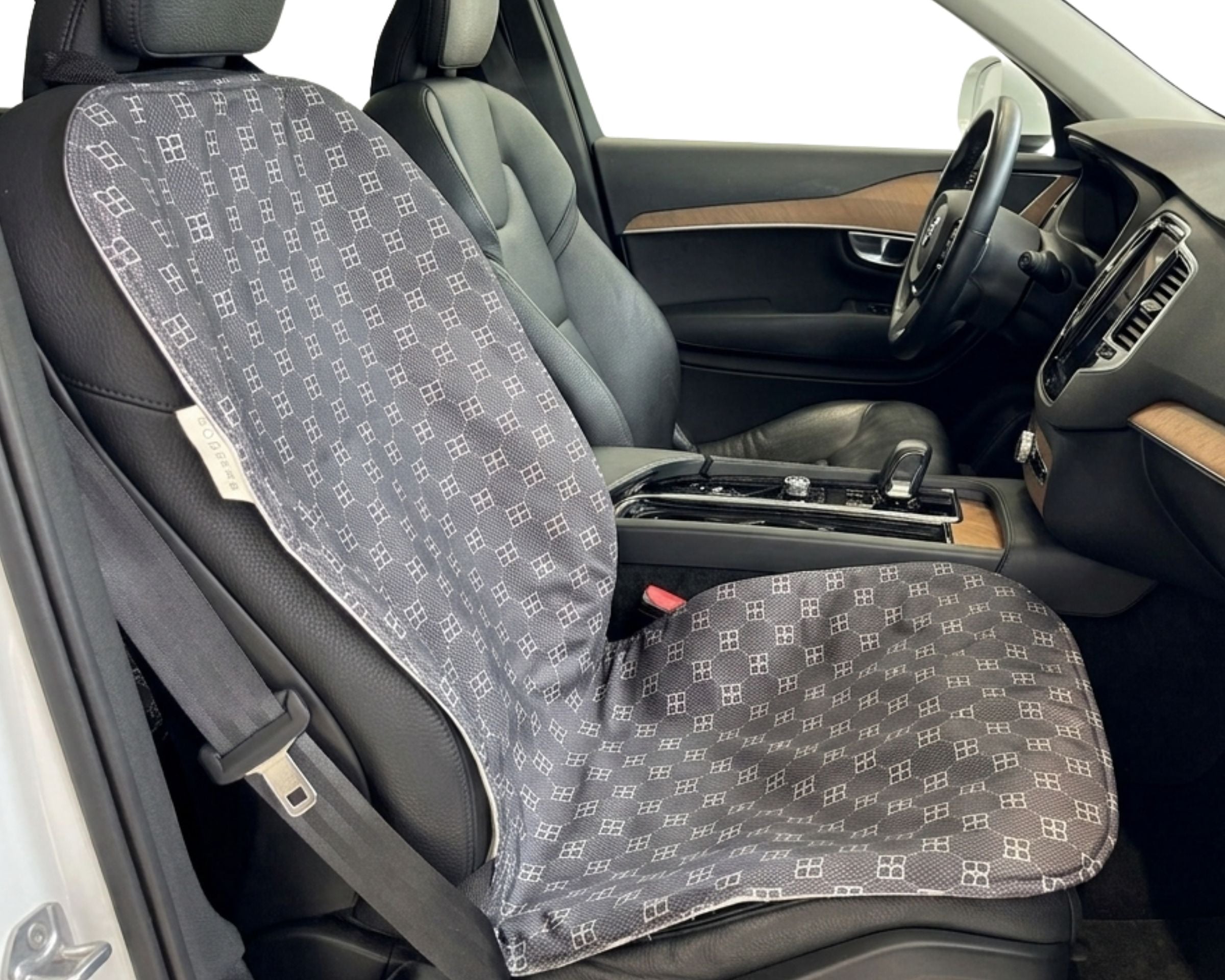 Bowsers Single Bucket Seat Cover  A pair of car seat covers with a gray and white geometric monogram pattern, shown installed on the front seats of a vehicle interior.