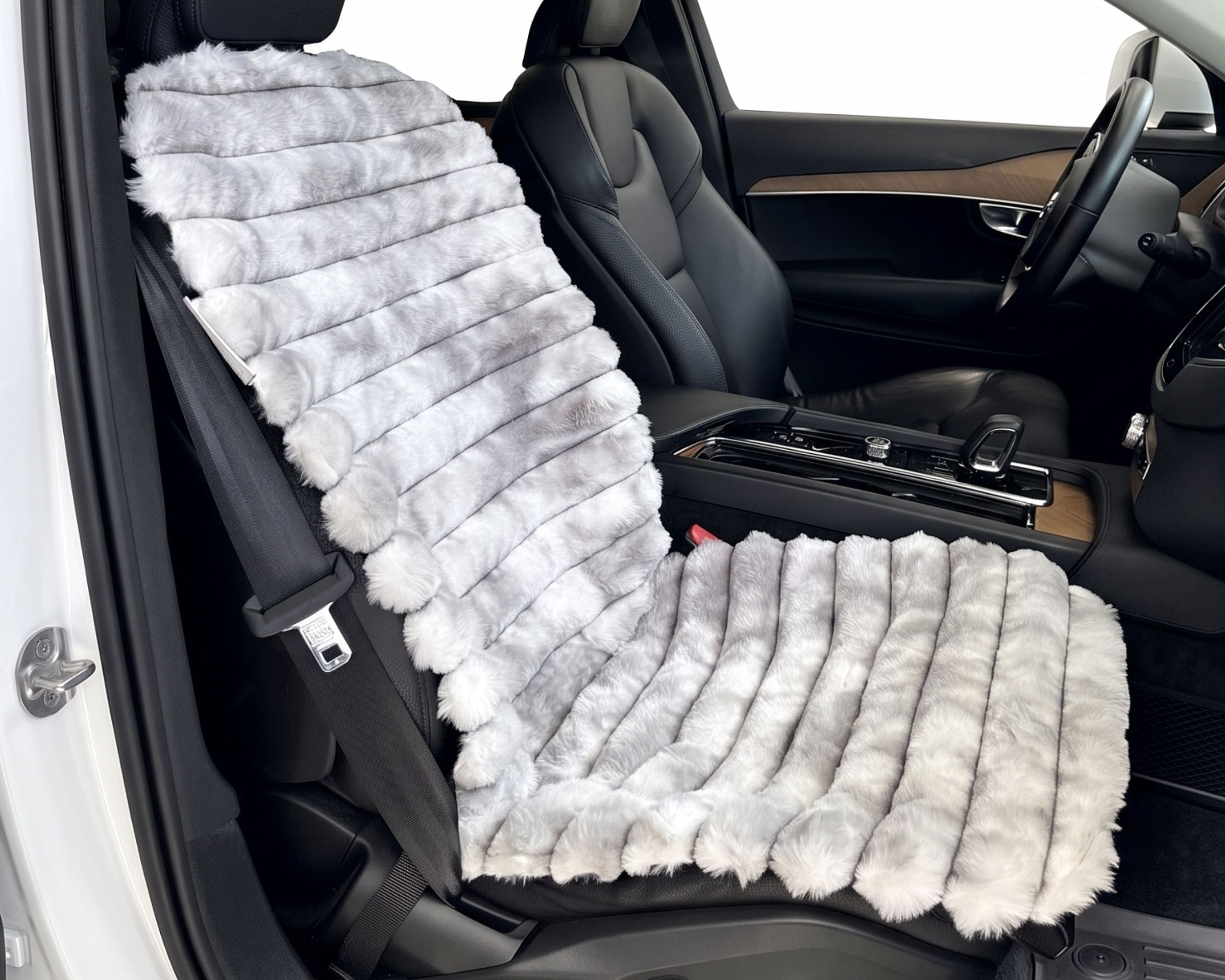 Bowsers_Single_Bucket_Seat_Cover_ A plush, ribbed faux fur car seat cushion set in light gray and white, shown installed on the front seat of a black car interior.