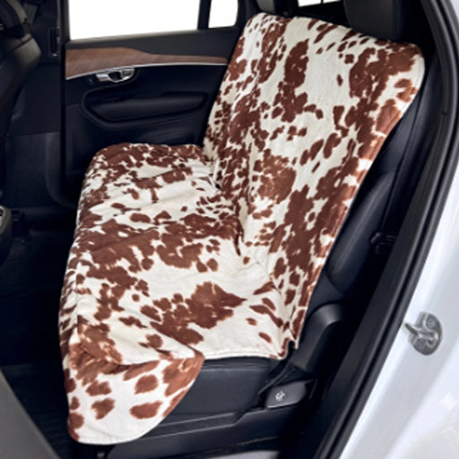  Bowsers Bench Seat Cover A car seat cover with a brown and cream cow print pattern draped over a vehicle's rear seat.