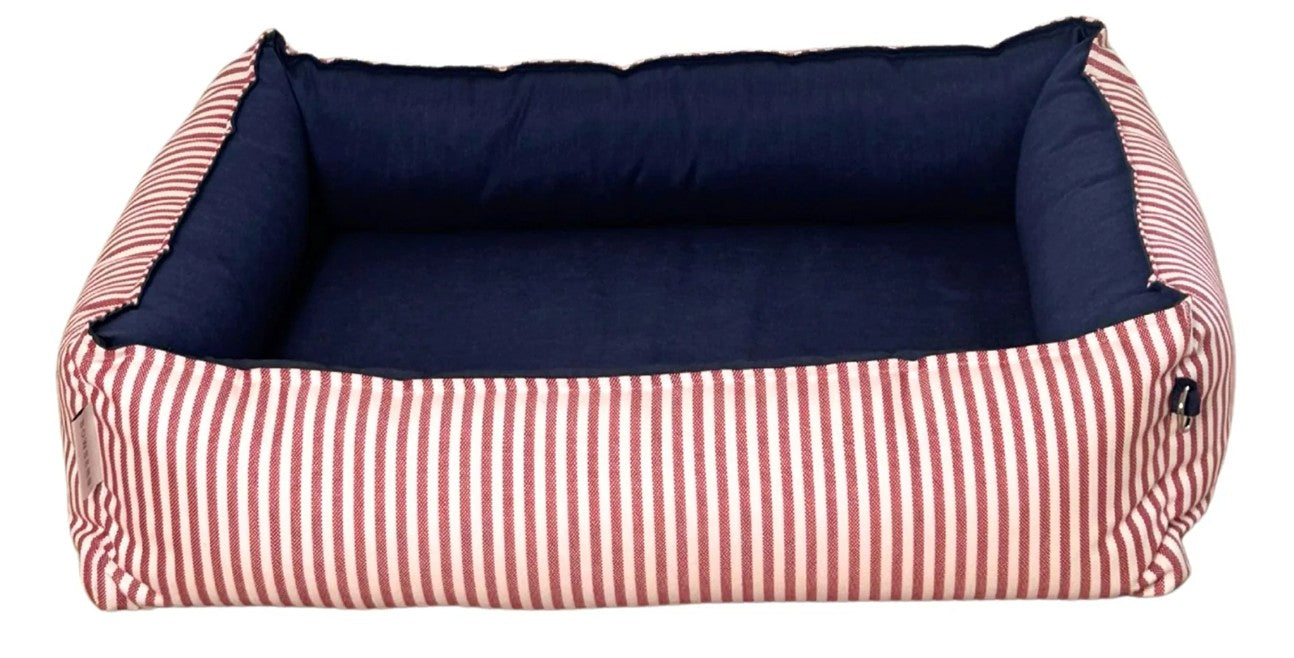 A rectangular pet bed with a navy blue cushioned interior and a red-and-white vertically striped fabric exterior, shown on a plain white background.