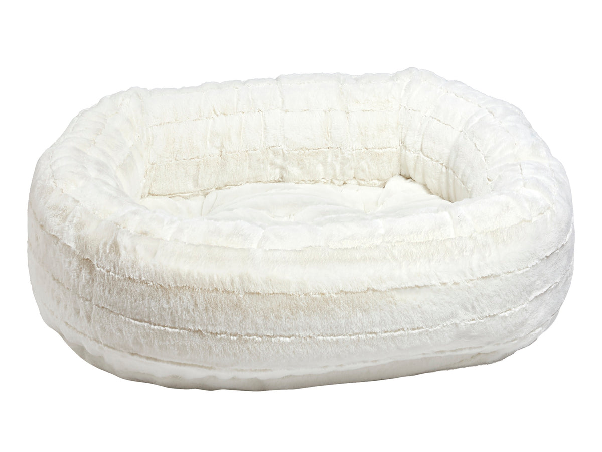 A plush, round pet bed in a warm off-white or cream color, featuring a quilted texture and a soft, cushioned interior, shown against a plain white background.