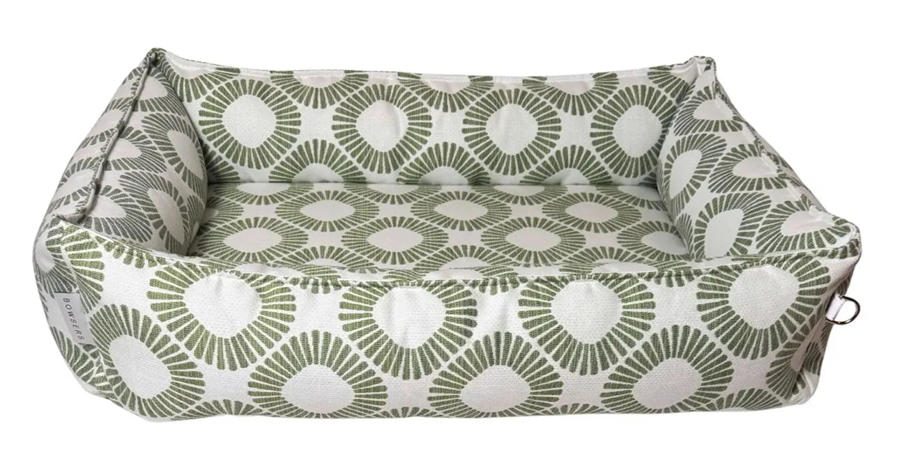 A rectangular cushioned pet bed with a green and white geometric fan pattern, shown against a plain white background.