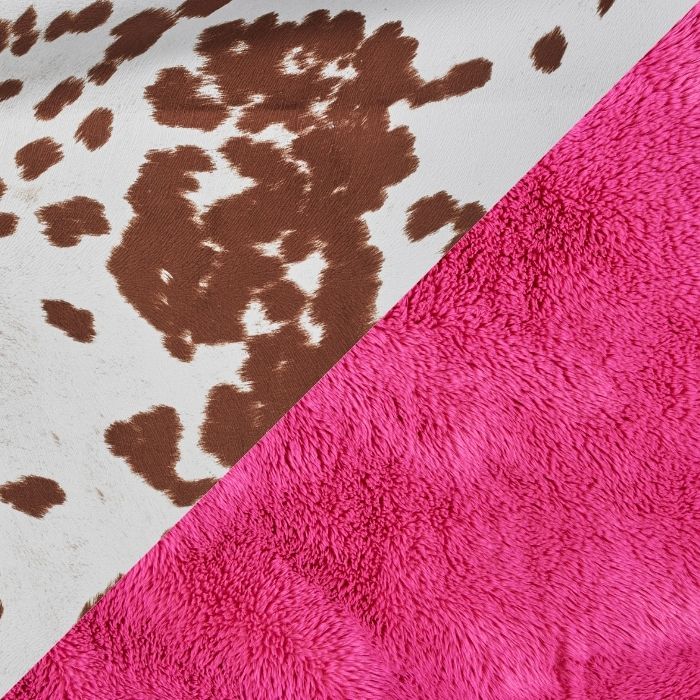 A close-up of two textured fabrics meeting at a diagonal split: one bright hot pink faux fur, and the other white cowhide with brown spots.