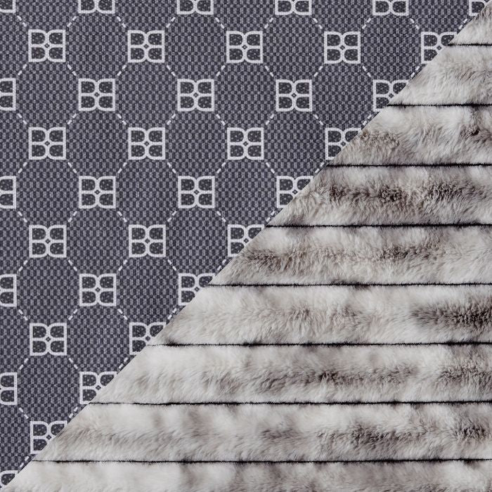 A close-up of a split fabric/material sample: the left half shows a dark gray and white repeating geometric monogram pattern, and the right half shows a soft faux-fur texture in gray, white, and taupe tones.