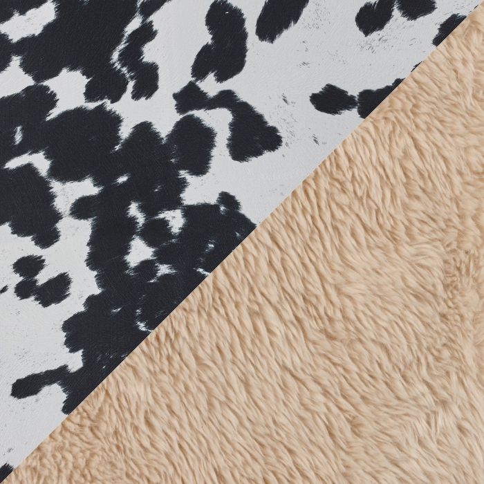 Close-up of a patterned fabric with black and white abstract design and beige textured surface.