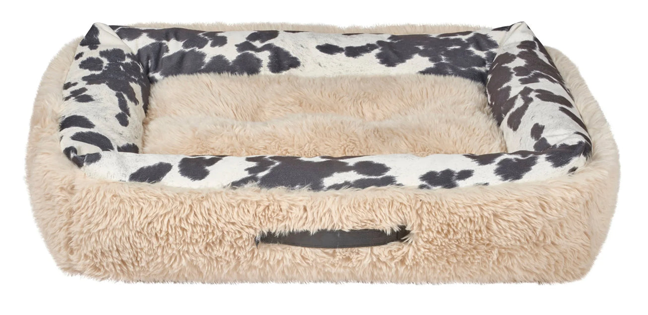 A rectangular pet bed with a fluffy beige faux-fur exterior and a black-and-white cow-print cushioned interior, shown on a plain white background.